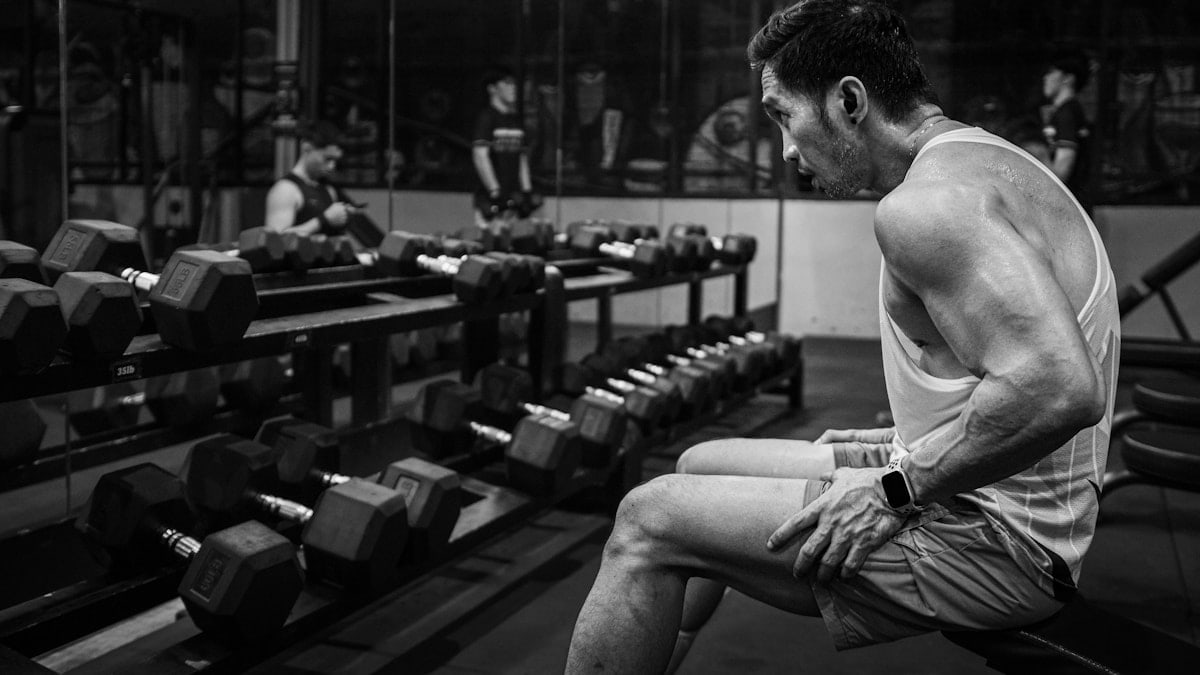 A man sitting on a bench in a gym